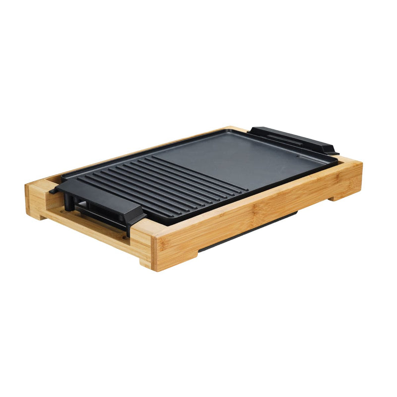 Electric grill with a ridged surface on a wooden base, isolated on a white background.