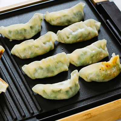 Dumplings on a black grill pan.